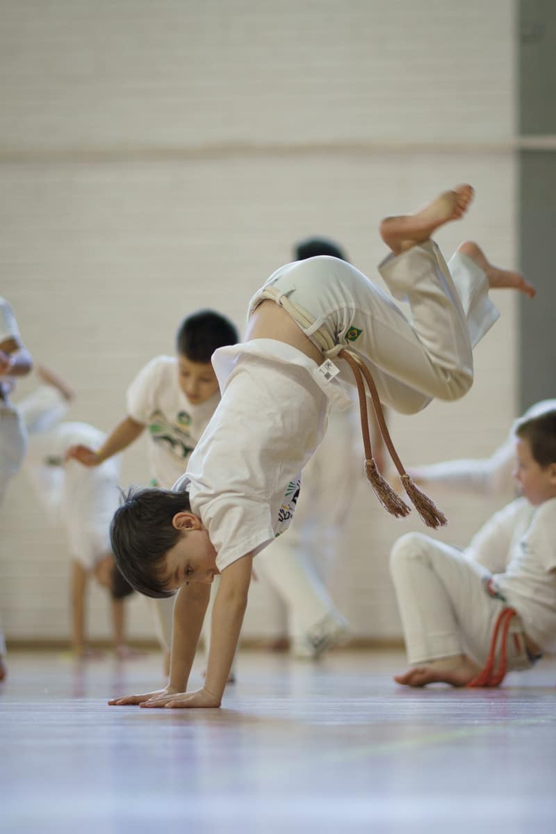 Dzieci podczas wspólnej rozgrzewki na treningu Capoeira dla dzieci w Klubie Sportowym Capoeira Camangula Poznań