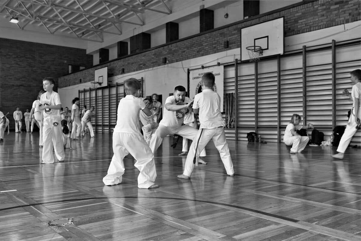 Instruktor pokazuje ćwiczenia podczas pierwszego treningu Capoeira dla dzieci